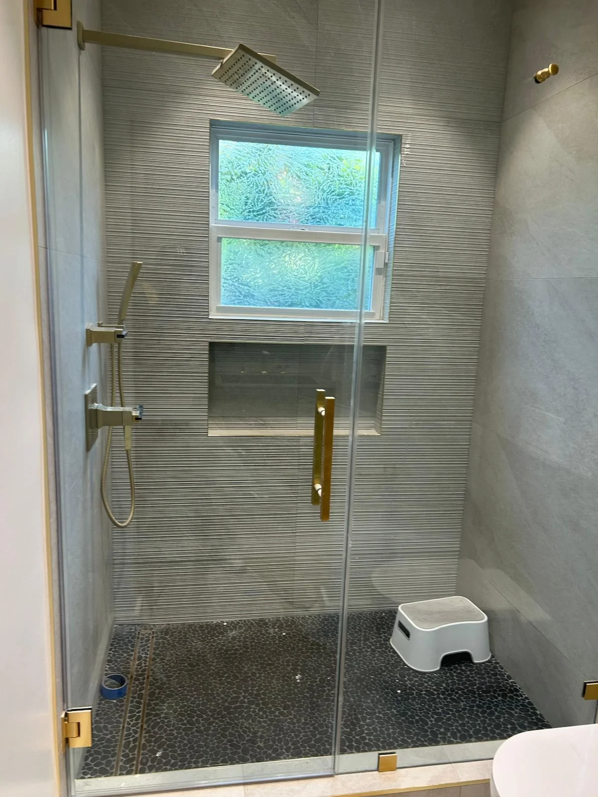 Glass shower with gold fixtures cleaned streak-free